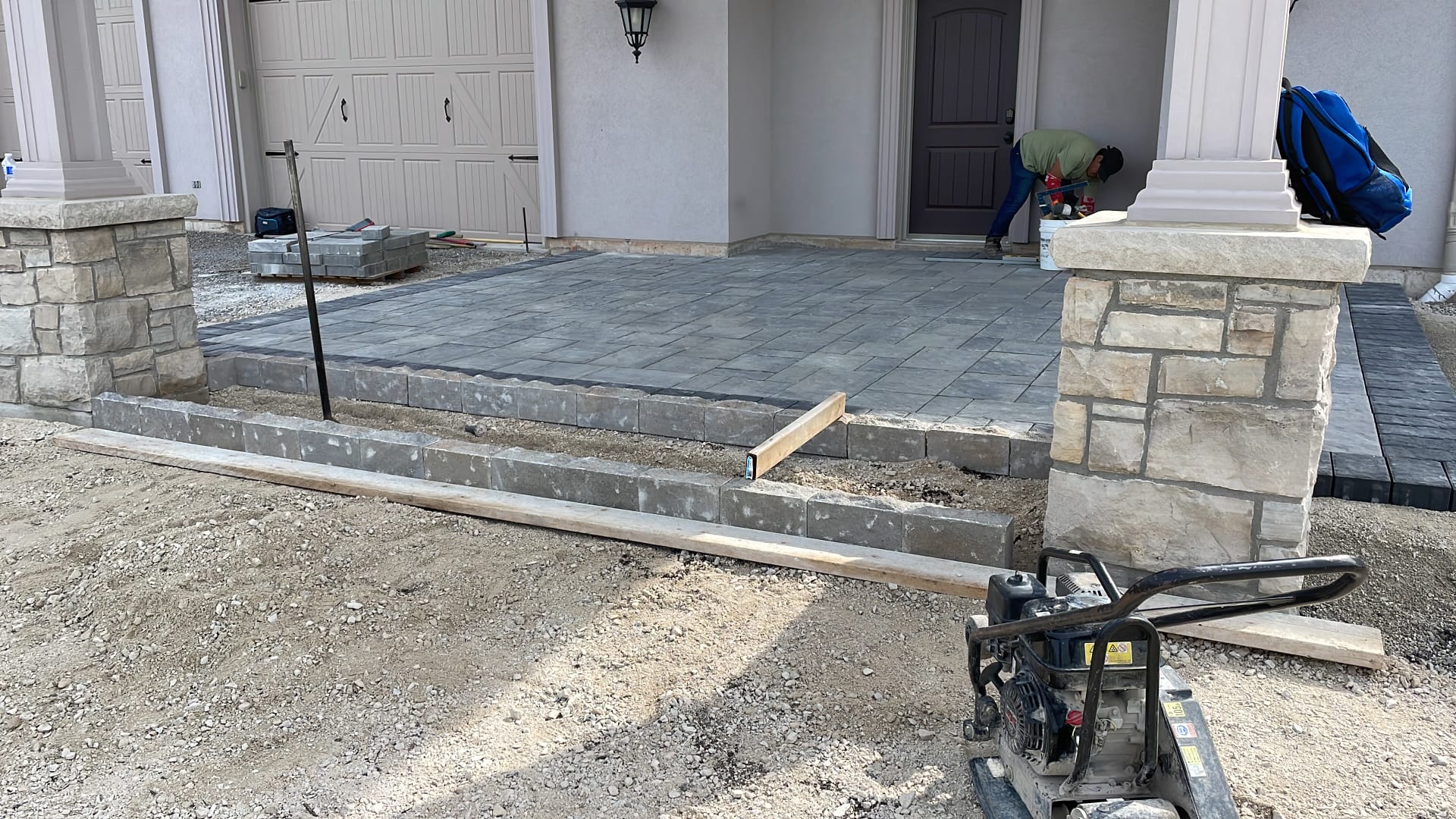 Front entrance interlocking paver installation with stone pillars in Toronto